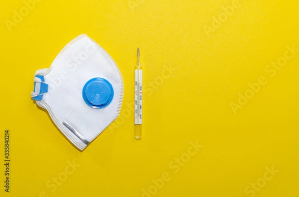 Fototapeta respirators and thermometer on a yellow background