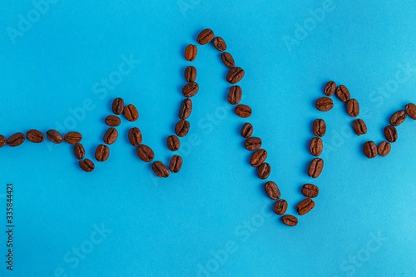 Fototapeta coffee beans show a bullet on a blue background