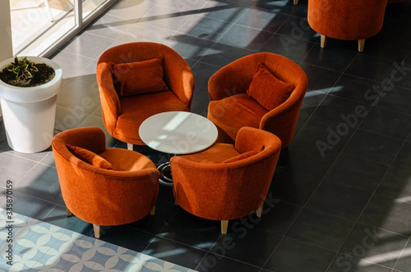 Obraz Orange chairs and table in a hotel lobby