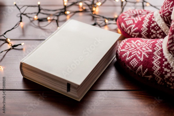 Obraz white book and red boots with christmas lights
