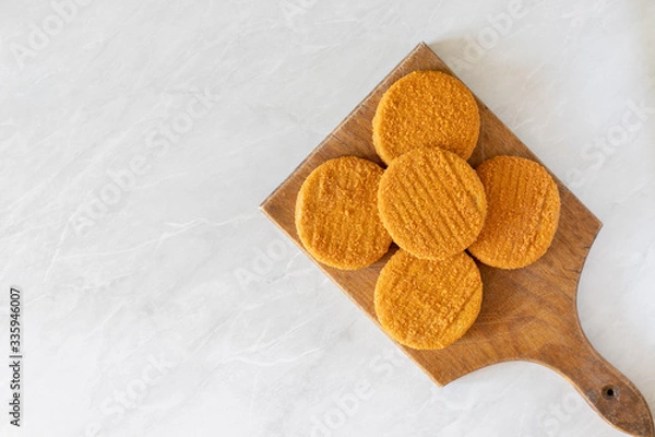 Obraz Round Fishcakes on the wooden board with copy space above grey marble table
