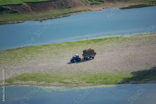 Fototapeta river tractor haystack summer grass meadow