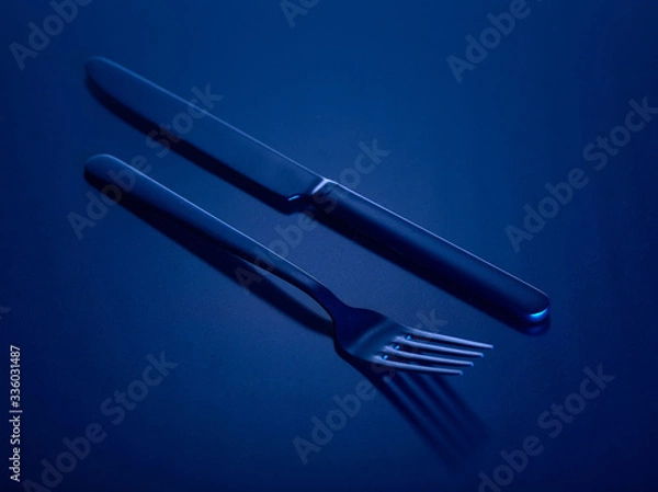 Fototapeta Knife and fork on a blue beautiful background. You can change the color.