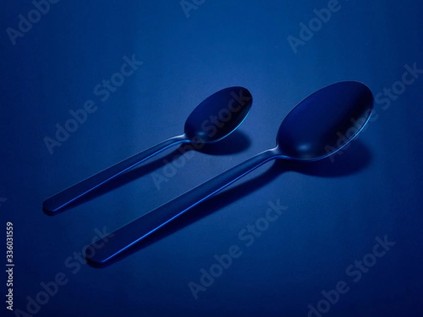Fototapeta Two tablespoons of dining and dessert on a blue beautiful background. You can change the color.