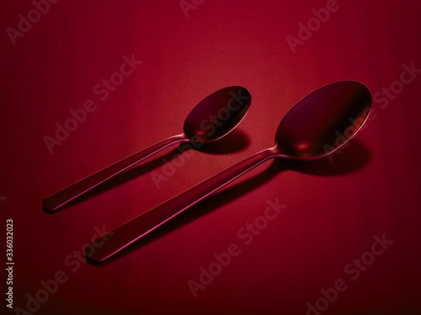 Fototapeta Two tablespoons of dining and dessert on a red beautiful background. You can change the color.