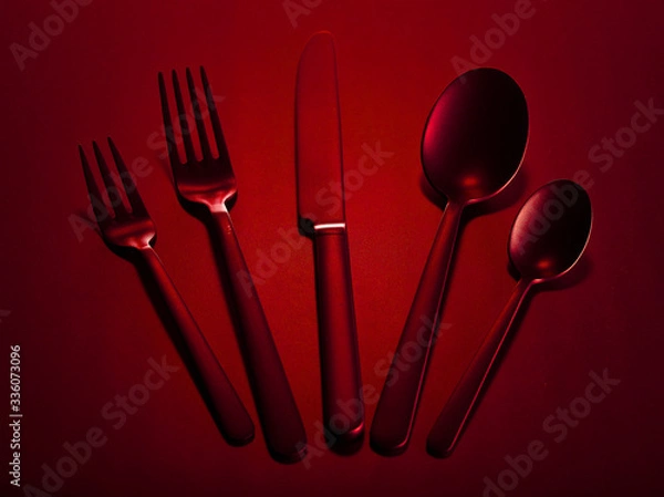 Fototapeta Red set of kitchen appliances knife, spoons and forks group on a red beautiful background. You can change the color.