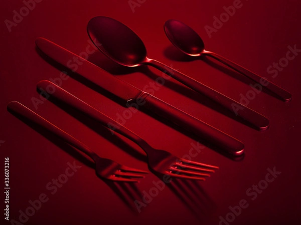 Fototapeta Red set of kitchen appliances knife, spoons and forks group on a red beautiful background. You can change the color.