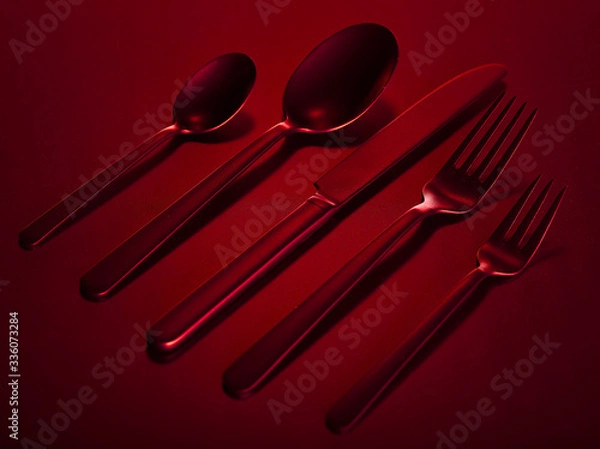 Fototapeta Red set of kitchen appliances knife, spoons and forks group on a red beautiful background. You can change the color.