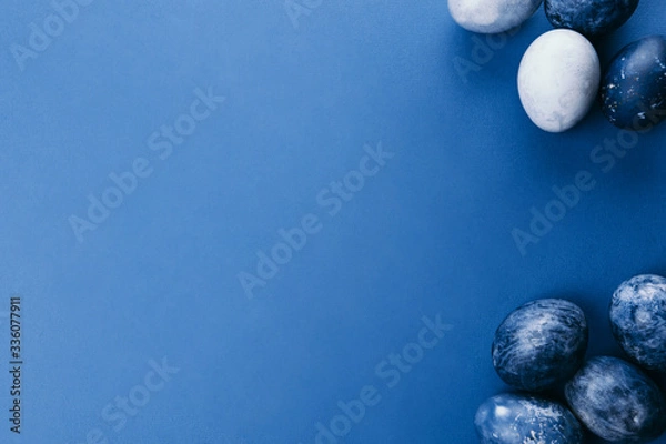 Fototapeta Beautiful group ombre blue Easter eggs with quail eggs and feathers on a blue background. Easter concept. Border eggs. Copy space for text
