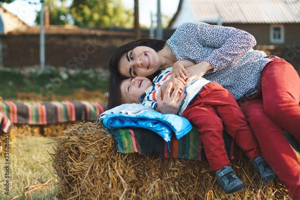 Obraz laughing mother and son on haystack