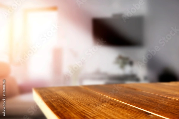 Fototapeta Wooden table in the living room by a sunny window on a warm day