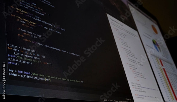 Fototapeta Close view of a computer screen with programming code and charts about coronavirus crisis evolution