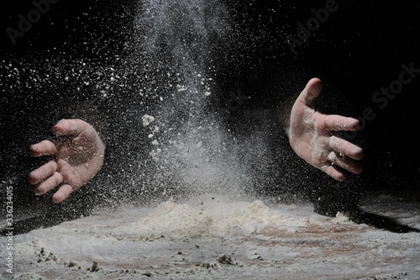 Fototapeta hands flapping flour in the dark. the flour is flying