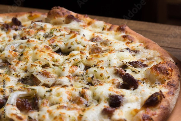 Obraz Delicious meat pizza on wooden board. Made with Mozzarella, picanha meat, onion, cheese, tomato sauce. Filet Steak, meat. Horizontal photograph with blurred background.