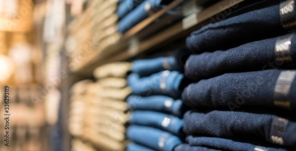 Fototapeta Display shelves with denim pants jeans trousers in clothing  on the rack in department clothes of retail store.