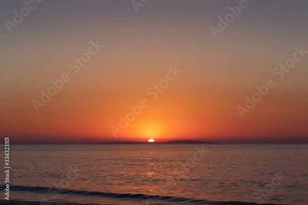 Obraz Sea coast at sunset, with the sun, wave, orange sky