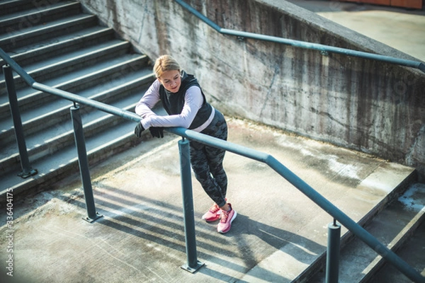 Obraz Young Caucasian woman taking a break after running