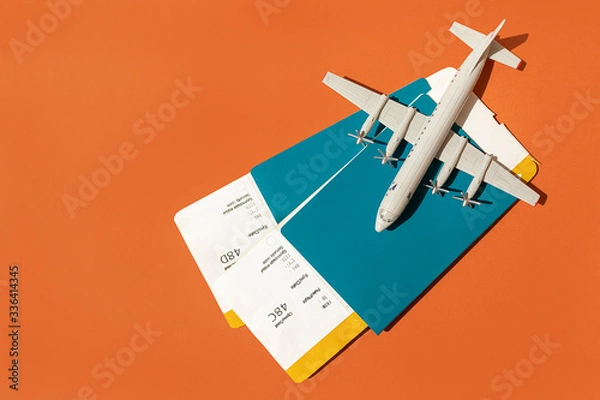 Fototapeta toy plane on the background of passports with tickets, the concept of resuming flights around the world after the coronavirus, financial losses of airlines and tour operators.
