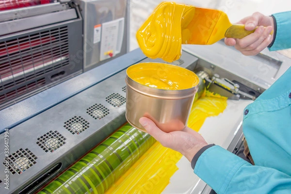 Fototapeta オフセット印刷機にインキを缶から供給する様子。