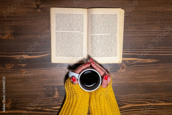 Obraz Shot from above of woman drinking coffee while reading a book