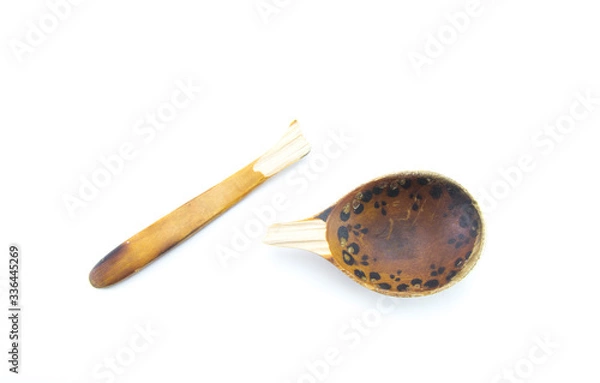 Fototapeta Old broken wooden spoon in light brown on a white isolated background.