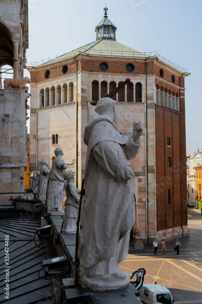 Fototapeta Cremona, Italy: View of the baptistery of the city and statue of a saint 