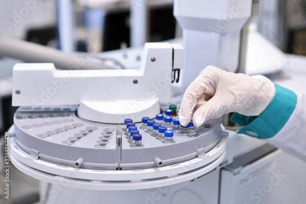 Fototapeta Quality Control Laboratory medicine. Chromatograph operation. A woman makes an analysis on a gas chromatograph. Development of a new vaccine against the covid-19 virus.
