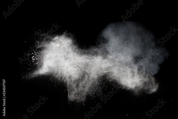 Fototapeta White dust is scattered by an explosion on a black background, an abstract cluster of white particles, a snowstorm on a black background