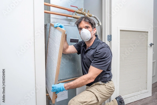 Obraz HVAC worker replacing filter