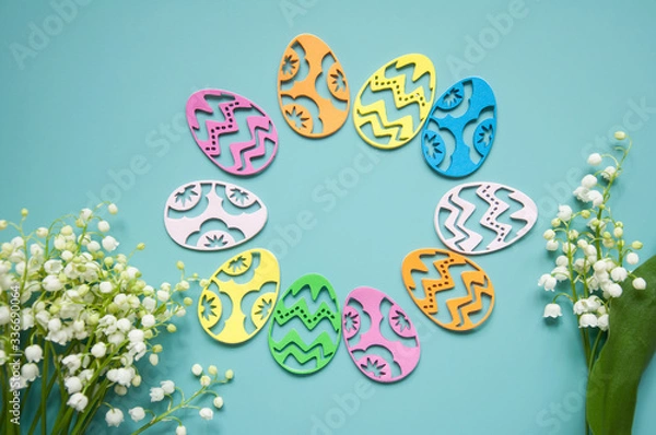 Fototapeta Floral blue background with fresh flowers. Spring greeting card for Easter. A bouquet of lily of the valley and a gift, eggs