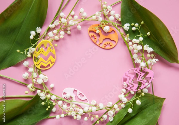 Fototapeta Floral pink background with fresh flowers. Spring greeting card for Easter. A bouquet of lily of the valley and a gift, eggs