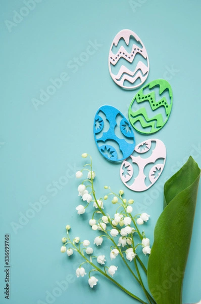Fototapeta Floral blue background with fresh flowers. Spring greeting card for Easter. A bouquet of lily of the valley and a gift, eggs
