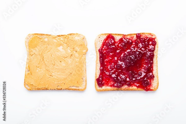 Obraz Peanut butter and jelly sandwich halves on a white background, top view