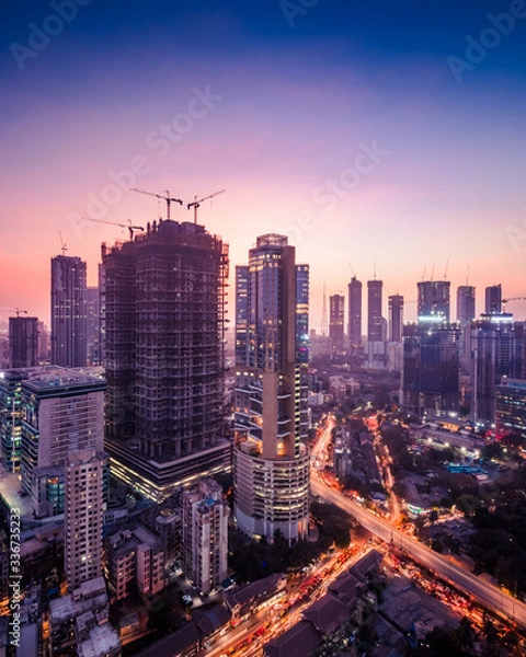 Fototapeta Twilight view of the Mumbai cityscape in purple hues showing a lot of under construction and existing residential and commercial skyscrapers and highrises.