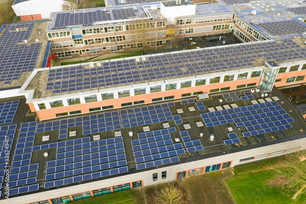 Obraz Drone photo of a large school building for vmbo, mavo ,havo and vwo education.n1100 solar panels have been installed on the roof of this school for green energy.