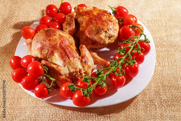 Fototapeta Fried chicken and tomatoes are on a plate. Home cooking.