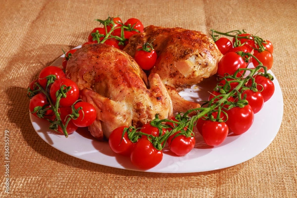 Fototapeta Fried chicken and tomatoes are on a plate. Home cooking.