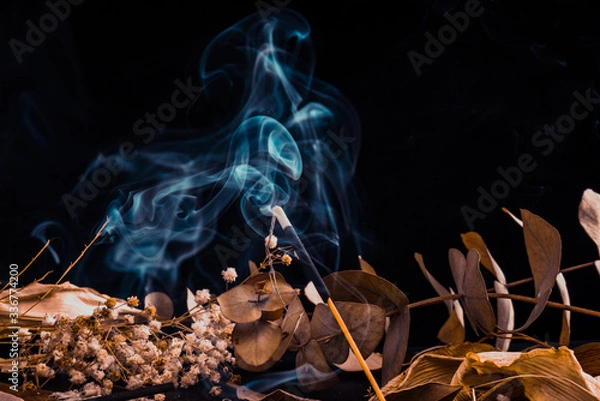 Fototapeta Stick holder and incense stick with leaves and flowers on black background