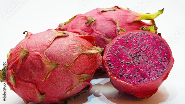 Fototapeta Colorful juicy dragon fruit on a white background. tropical fruit close, cut of purple pitahaya fruit. purple cactus with seeds inside