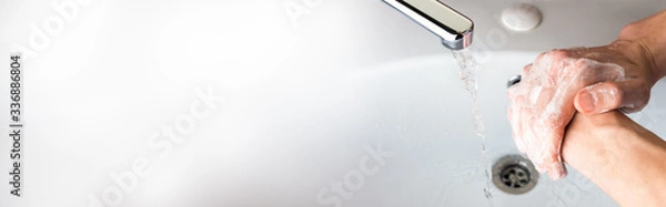 Obraz Washing hands with soap   under a stream of water  in the bathroom over the sink. Close-up of men's hands. Hygiene concept for protection against coronavirus infection.  Banner background