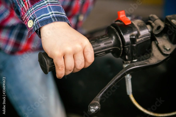 Fototapeta Close-up children's hand on the handle of an old motorcycle