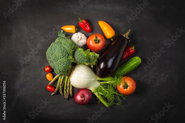 Obraz Exposition of fresh organic vegetables on black table. tomato, pepper, broccoli, onion, garlic, cucumber,  eggplant, black Eyed Peas, ecological bag.