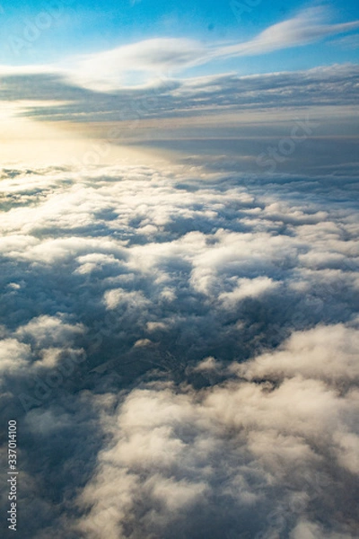 Fototapeta Clouds from above from an airplane on a sunny day.