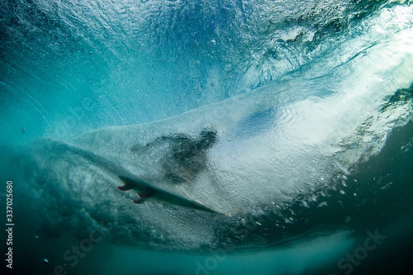 Fototapeta underwater shot of a surfer riding a tube or barrel overhead
