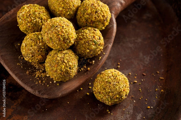 Obraz Handmade pistachio chocolate truffles on wooden background.