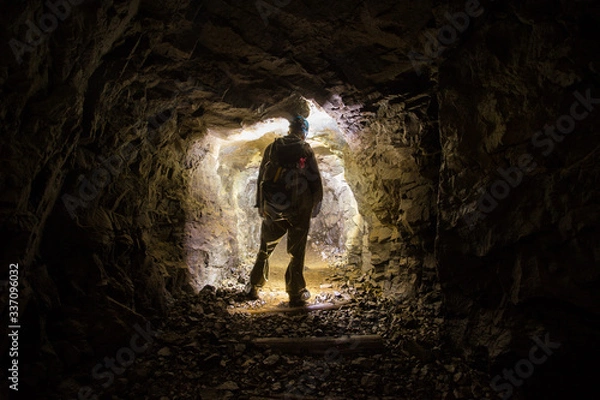 Fototapeta Underground abandoned platinum ore mine tunnel with miner