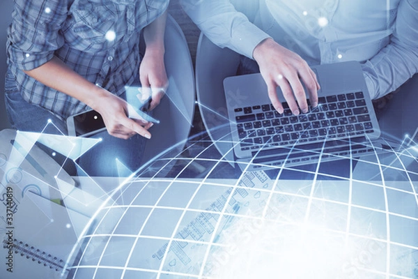 Fototapeta Double exposure of man and woman working together and world map hologram drawing. international network concept. Computer background. Top View.