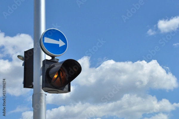 Fototapeta Pedestrian warning light on a pole with an arrow pointing right