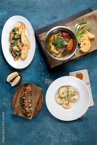 Fototapeta Several dishes in the frame of ear, dumplings, snacks and sandwiches