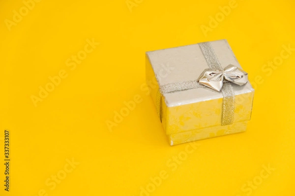 Fototapeta Silver gift box on yellow background. Copy, empty space for text